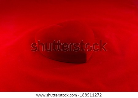 Heart\'s shape red velvet box on red background