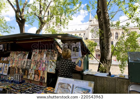 PARIS, FRANCE, August 5, 2014: Vintage books and pictures in open book market on embankment of river Seine near cathedral de Notre Dame. Book market on the banks of Seine is there since 16th century