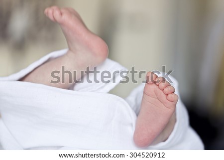 Close up picture of new born baby feet on a white sheet