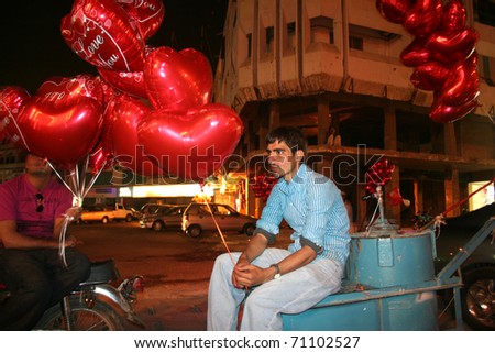 KARACHI, PAKISTAN -- FEB 13: An unidentified man sells Valentine\'s Day balloons at a busy intersection in Karachi, Pakistan on February 13, 2011.