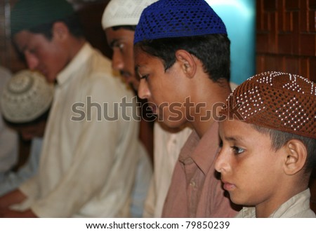 KARACHI, PAKISTAN - JULY 10: Unidentified Muslim boys read the holy Qur'an in Karachi, Pakistan on July 10, 2010. The majority of the country's population practice Islam.