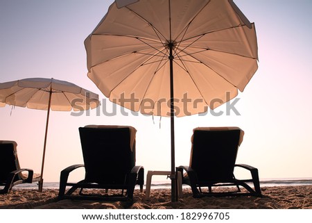 Two sun beach chairs in sunrise for relaxing