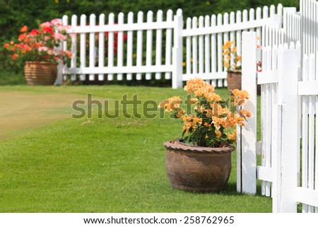 Paper flower  in pot against the white fence