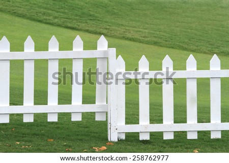 White picket fence and green grass