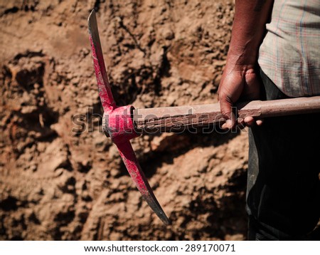 worker holding a construction equipment for digging soil