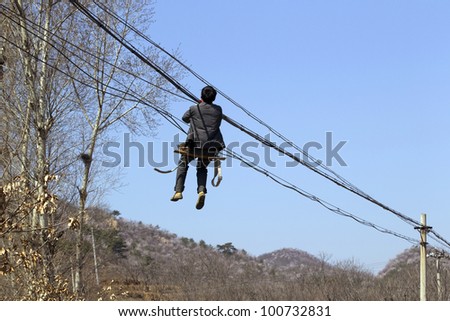 Worker repairing electrical power line, China