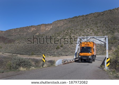 ORILLA VERDE RECREATIONAL AREA, NEW MEXICO, USA - April 16: Custom orange RV truck crossing Rio Grande bridge on April 16, 2014 at Orilla Verde Recreational Area, New Mexico, USA.