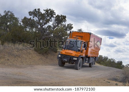 EL MORRO NATIONAL MONUMENT, NEW MEXICO, USA - April 18: Custom orange RV truck driving on dirt road on April 18, 2014 at El Morro National Monument, New Mexico, USA.