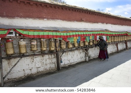LHASA - APRIL 5: A devoted Buddhist pilgrim spins prayer wheels at Potala on Monastery April 5, 2010 in Lhasa, Tibet Autonomous Region of China.