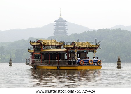 Traditional ornate boat and Leifeng Pagoda on famous Xihu West Lake, Hangzhou, China