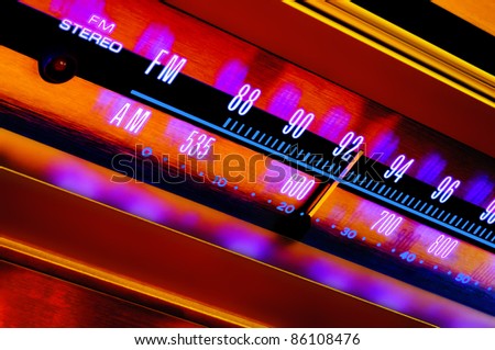 Vintage analog radio tuner dial FM/AM closeup with colorful psychedelic lighting