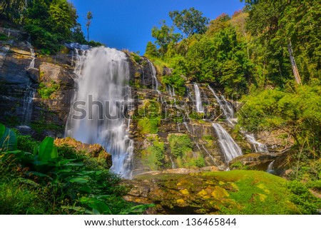 Beautiful water fall in spring season located in deep rain forest jungle.