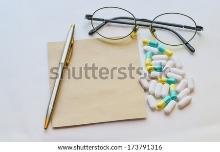 Medicine pill with glass and penand paper note. Health concept.