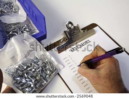 A worker records inventory counts on a clipboard