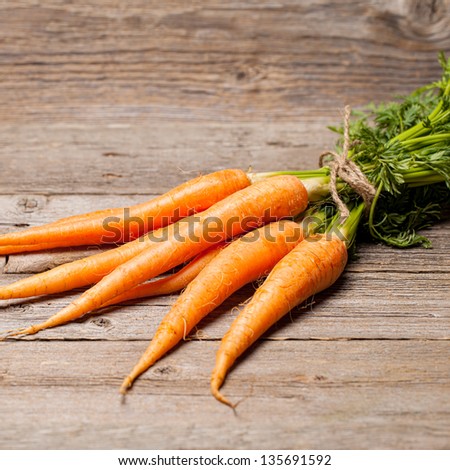 Fresh carrots on wooden table with focus on center