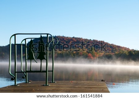 Decorative iron hand rail is attached to the dock with a view of the distant Adirondack mountain