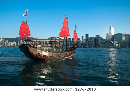 A traditional junk ship sails across Victoria Harbor in Hong Kong.