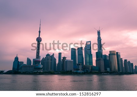 The sun rises over the skyscrapers of Shanghai.