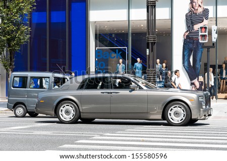 TOKYO, JAPAN - SEPTEMBER 19: A Rolls Royce stops at a traffic light in the upscale district of Ginza on September 19, 2013 in Tokyo, Japan.