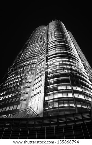 A modern skyscraper in Tokyo at night in black and white.