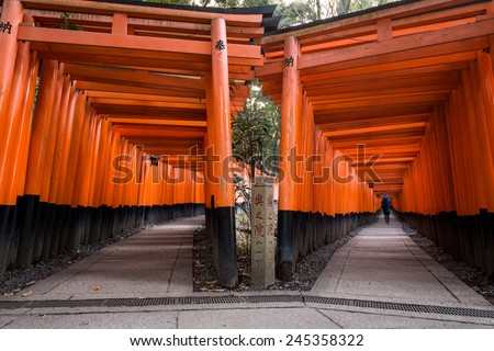 Thousands of red torii gates line two different paths at Fushimi Inari shrine in Kyoto, Japan.