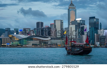 A junk ship sails through Victoria Harbor at night in Hong Kong.