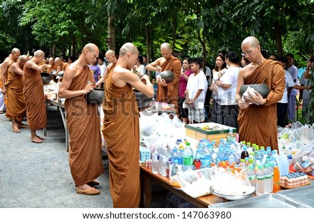 NAKORNNAYOK, THAILAND - JUL 22: Morning alms-offering to Buddhist monks to celebrate in 2013  religious ceremony Asarnha Bucha Day on 22 July 2013 at Temple Watnapapong, Nakornnayok, Thailand