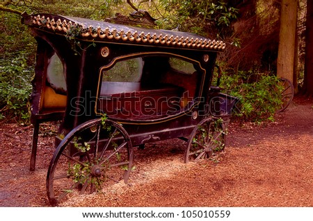Broken-old coach hearse with the coffin being in the wood .