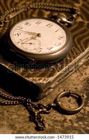 old pocket watch on a old worn book
