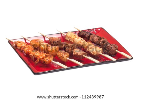 Delicious satay collection on a red plate with different meat