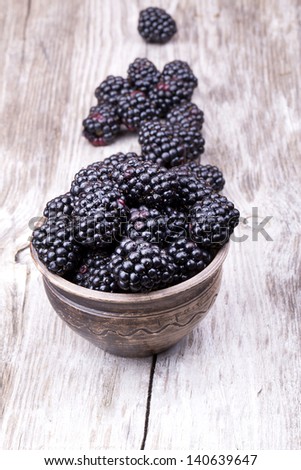 blackberries on wooden table with water drops background