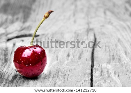 Cherries on wooden table with water drops macro background