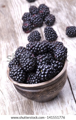 blackberries on wooden table with water drops background
