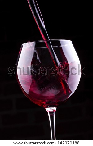 Splash red wine  against a black background