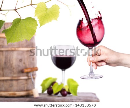 Red wine, glass barrel with grapes hand with glass over white