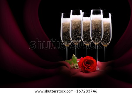 luxury champagne glass with red silk and flower on black background