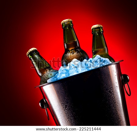 Beer bottles in ice bucket isolated on colored background