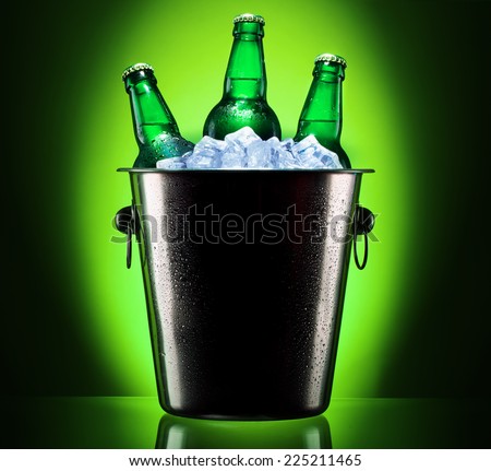 Beer bottles in ice bucket isolated on colored background