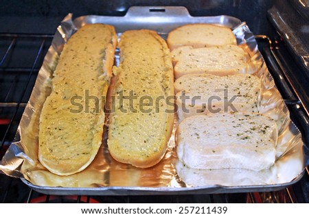 Delicious buttery garlic bread cooking on aluminum foil inside the oven
