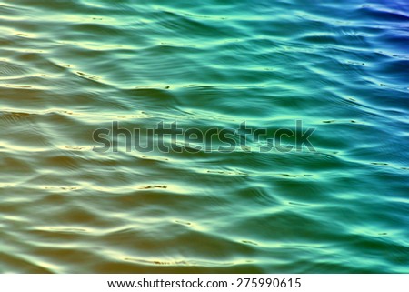 Soft ripples on surface of calm waters in shades of green and blue