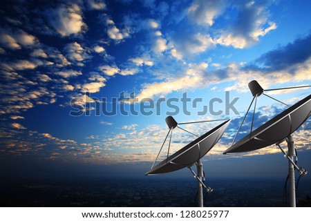 Satellite dishes on summit at sunset.