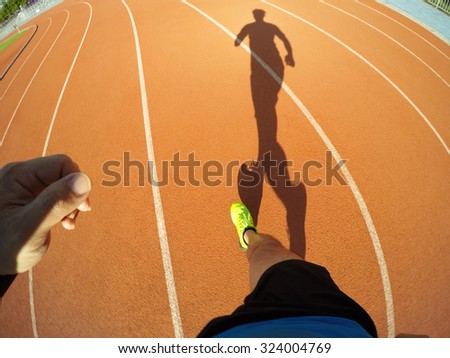 Man running on track, movement  shot.