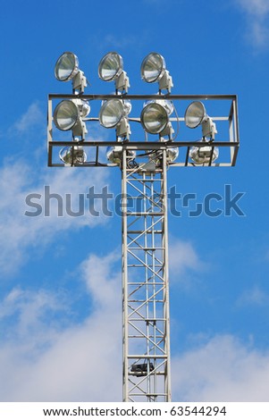 a football stadium floodlight with metal pole on blue sky