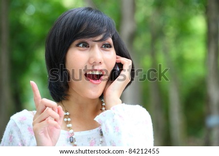 Asian female talking with someone from mobile phone happily.