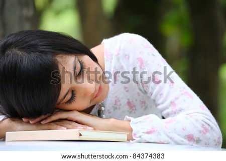 Portrait of a sexy young female sleep on a book in park - Outdoor
