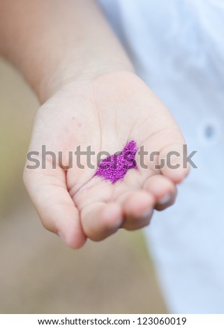 Hand holding purple glitter in shape of heart