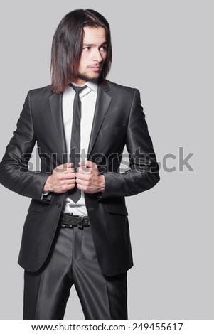 stylish man with long hair in elegant black suit