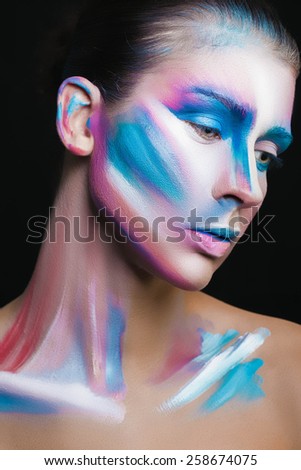 Beautiful fashion woman with bright color face art and body art. Paint on face. Creative portrait