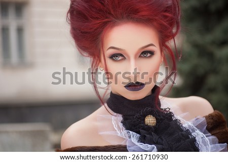 sexy woman with gothic makeup and red hair and castle