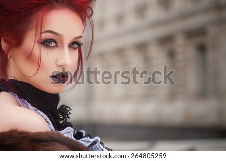 sexy vampire with gothic makeup and red hair and castle